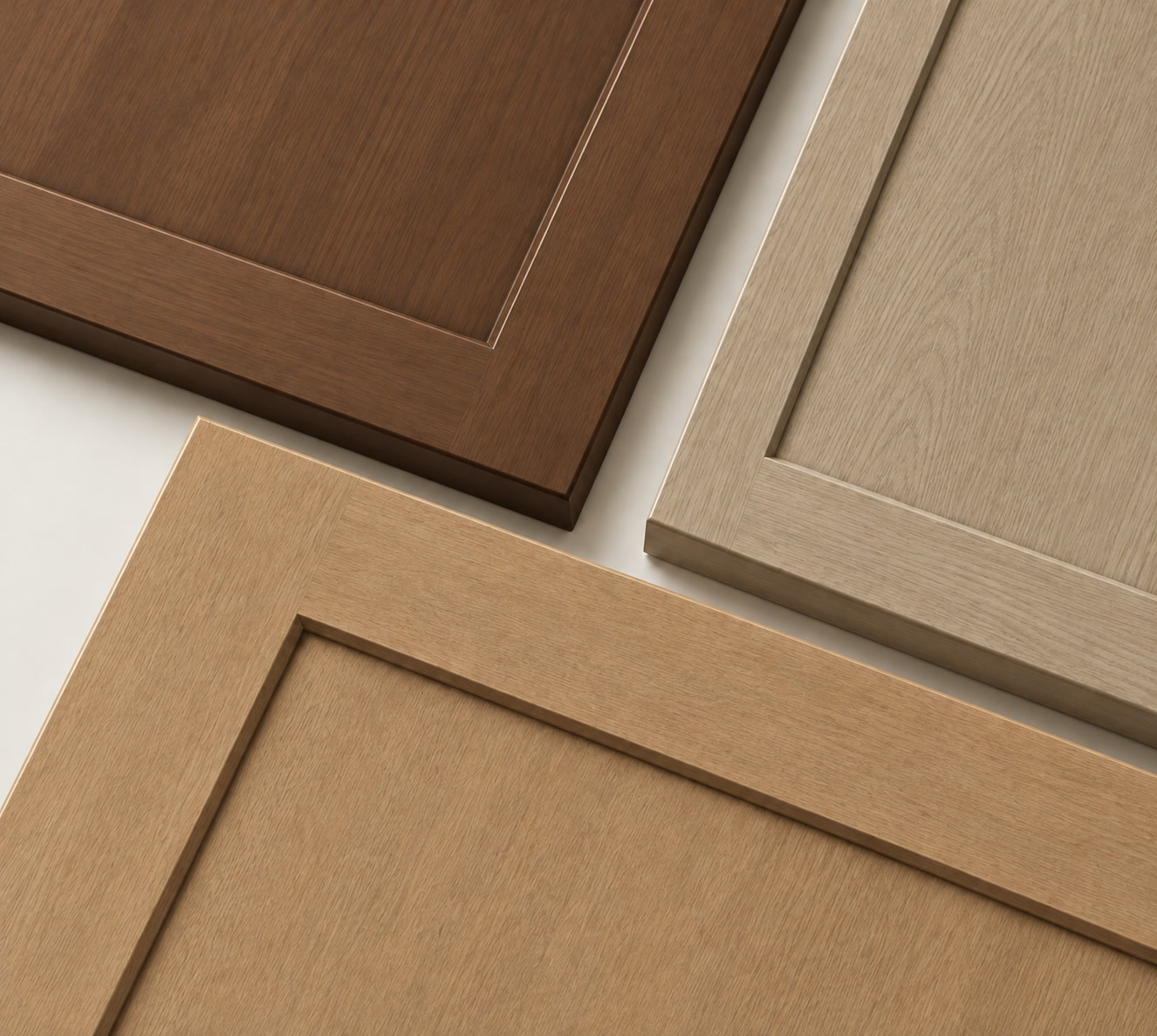 Three stained wood cabinet door samples in deep brown, pale neutral and warm natural tones